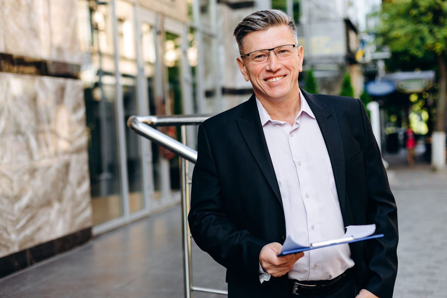 smiling-senior-businessman-in-glasses-holding-a-d-2024-10-18-10-01-19-utc
